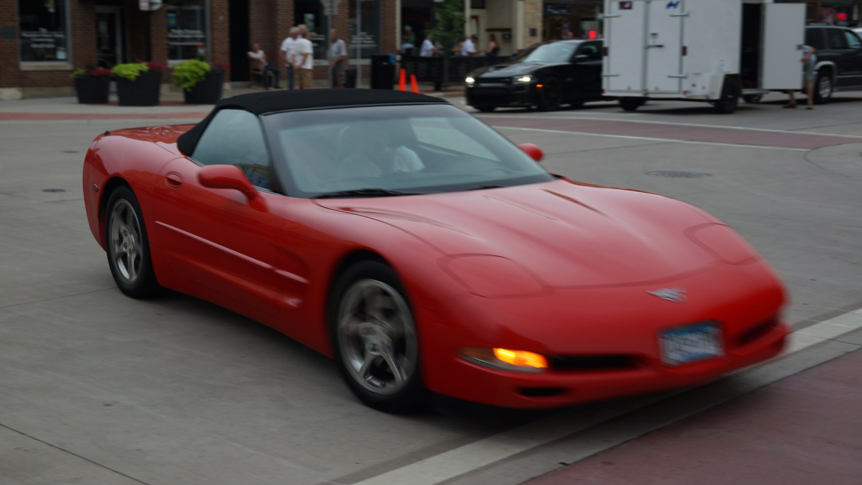 Red convertible sports car with aerodynamic front end and pop-up headlights