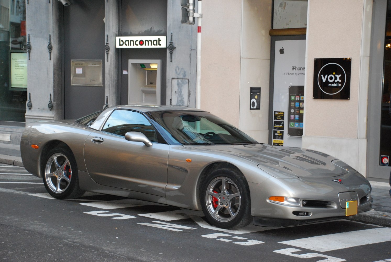 Side front view of a sleek sports car with aerodynamic body and iconic wheels