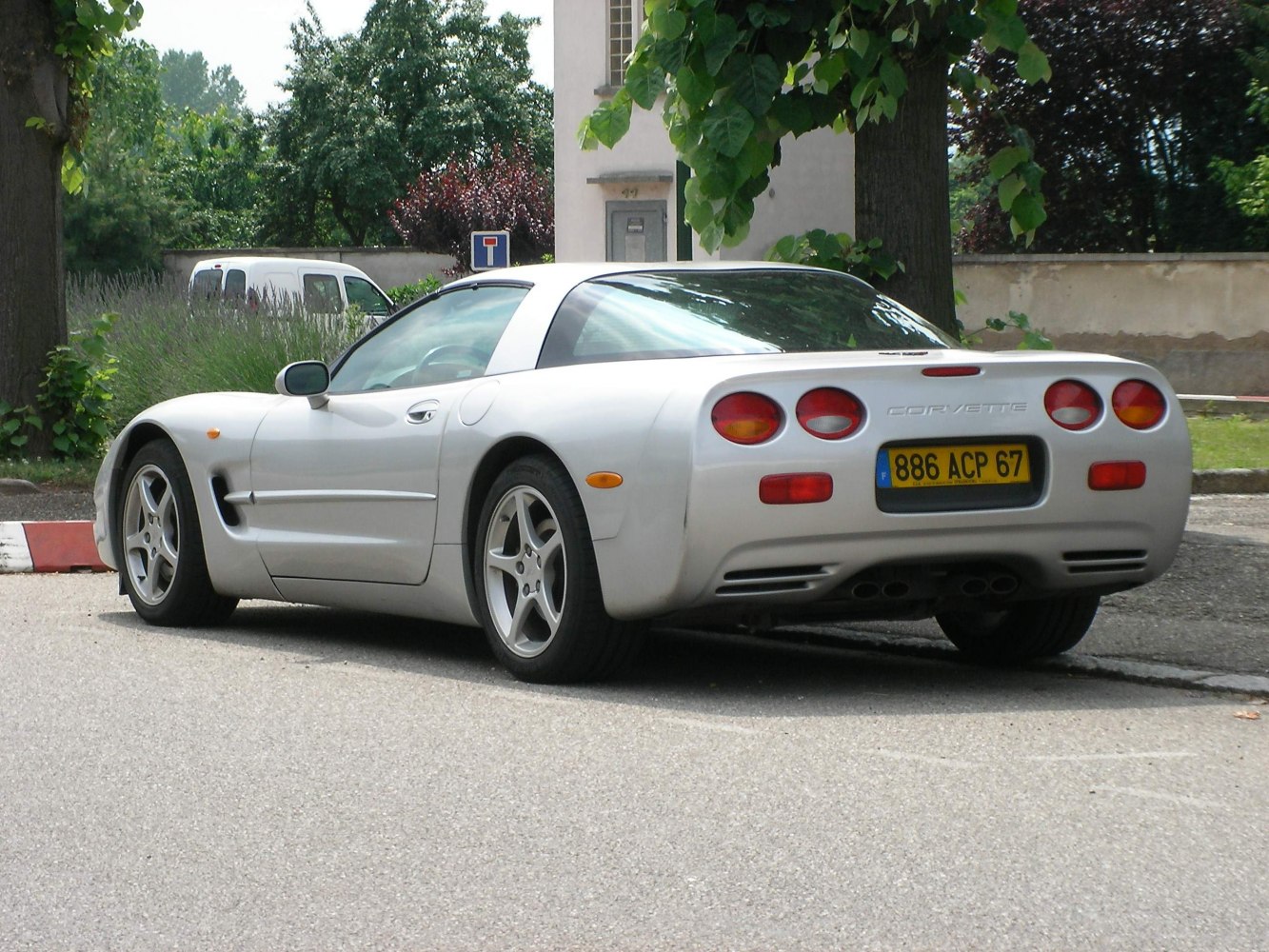 Rear side view of silver coupe with dual round taillights and sporty rear design