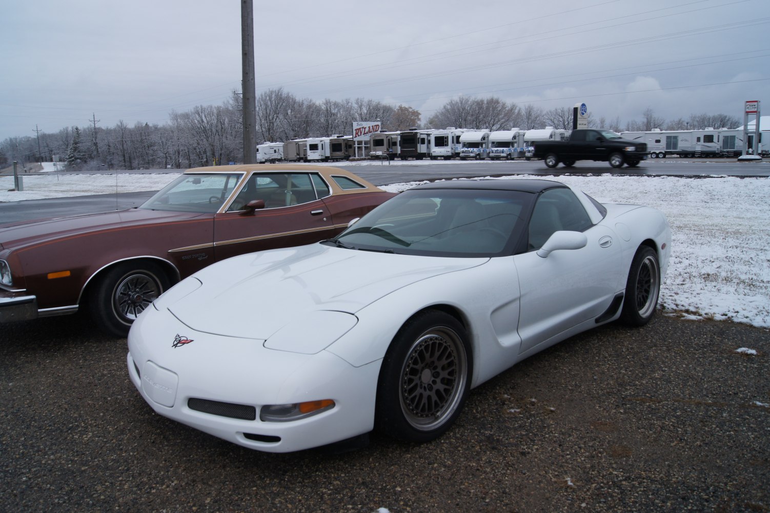 White sports coupe with black roof and detailed alloy wheels.
