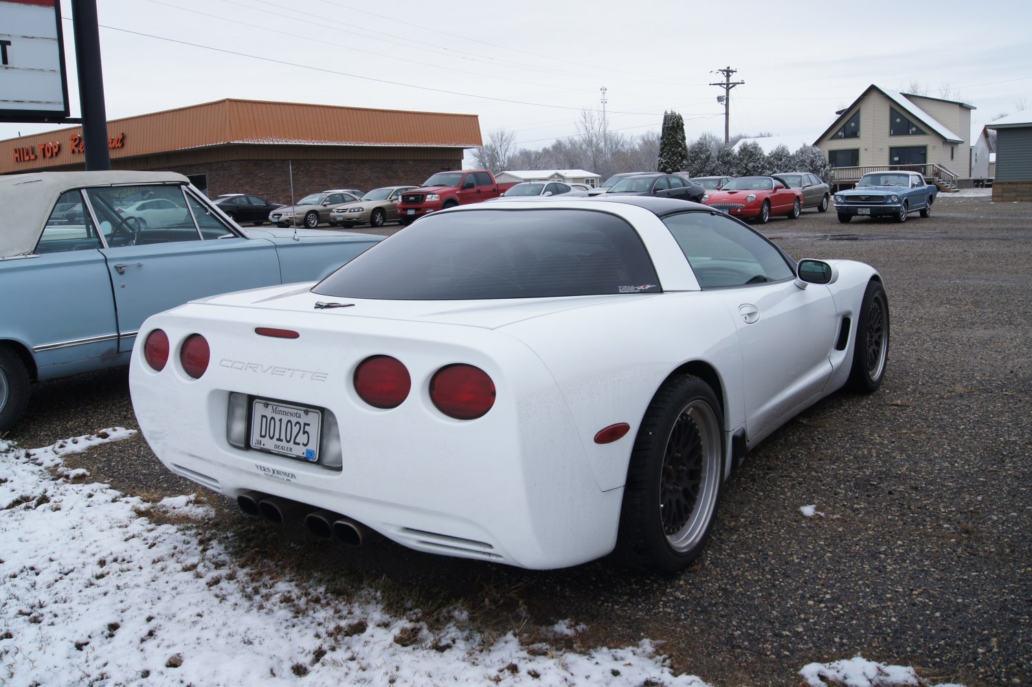 Rear view of a white sports coupe with quad exhaust and round taillights