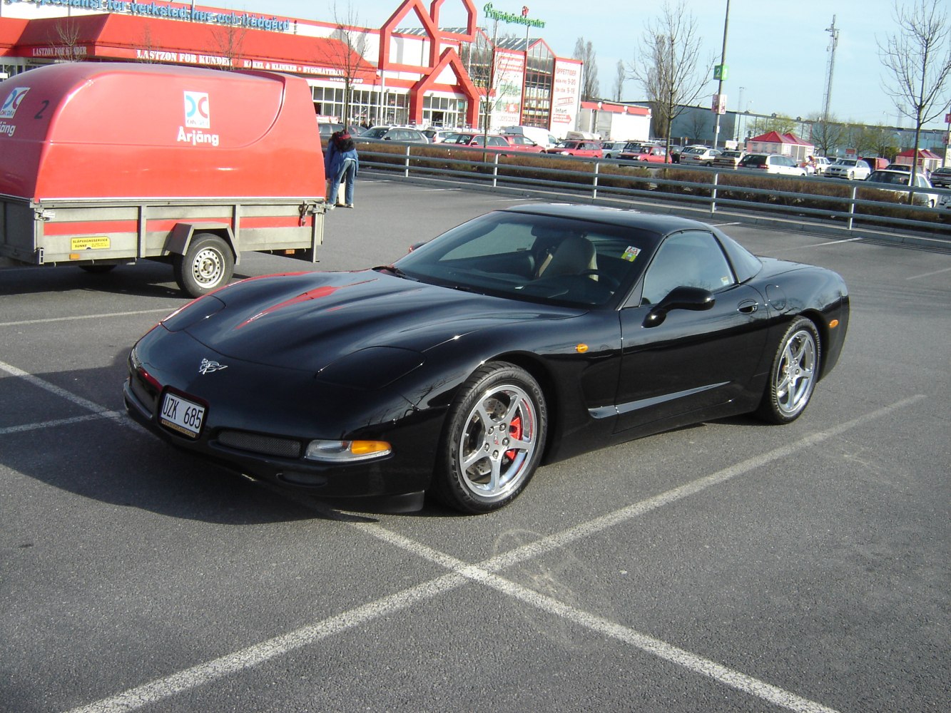 Black sports coupe with pop-up headlights and chrome wheels