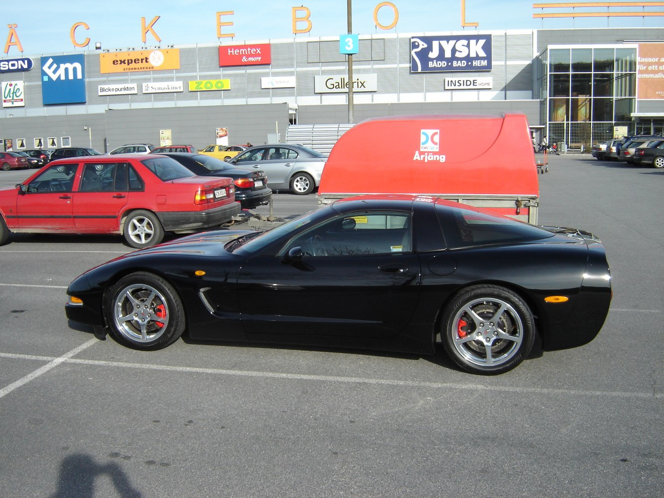 Side profile of black sports coupe with alloy wheels and sleek aerodynamic design