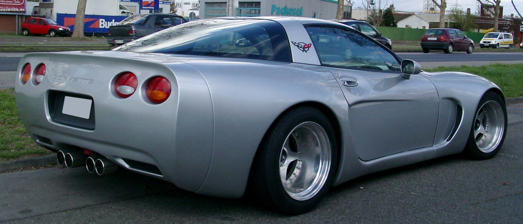 Silver coupe with quad exhaust and round tail lights.