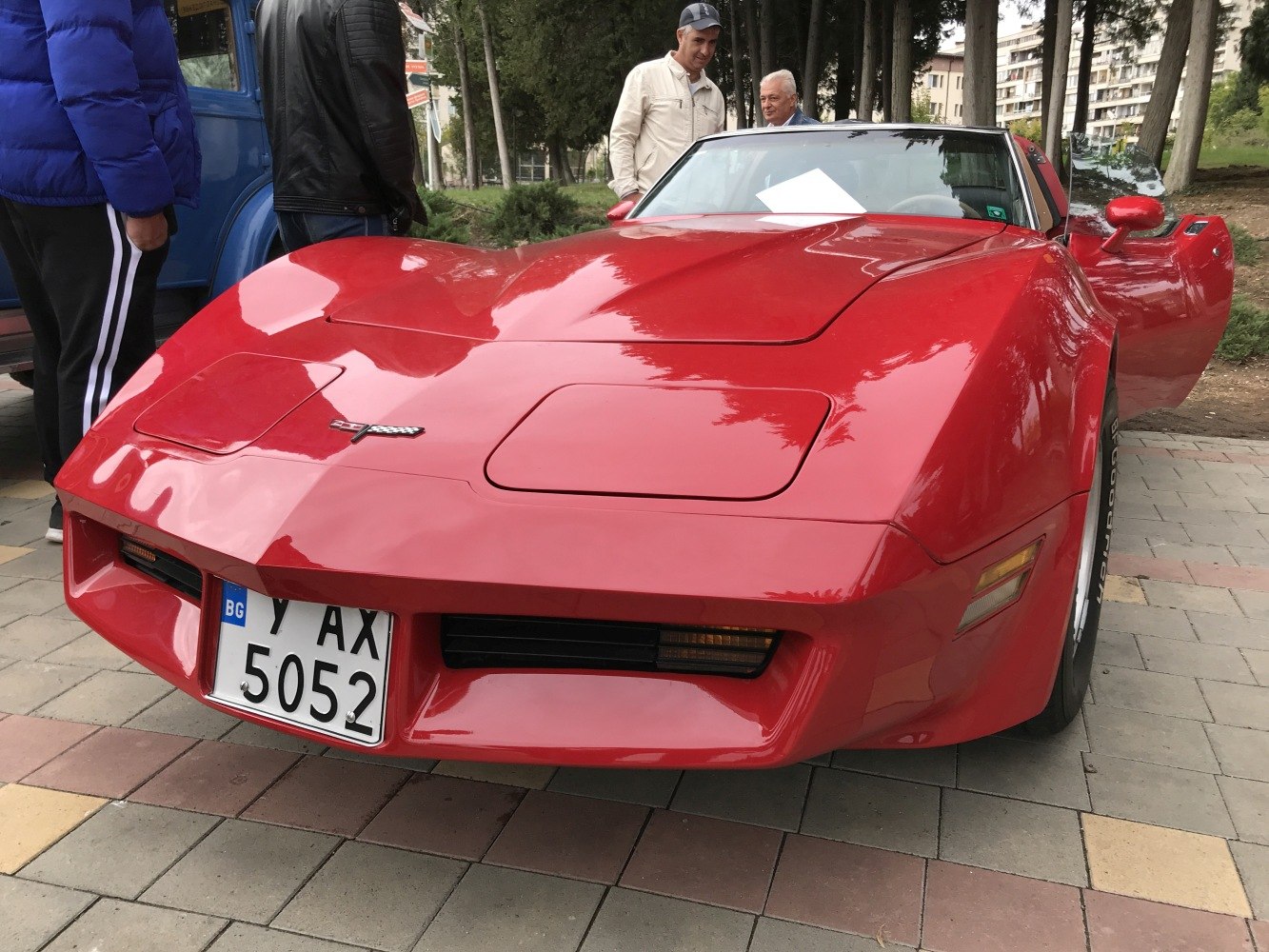 Front end with pop-up headlights and car badge in red coupe
