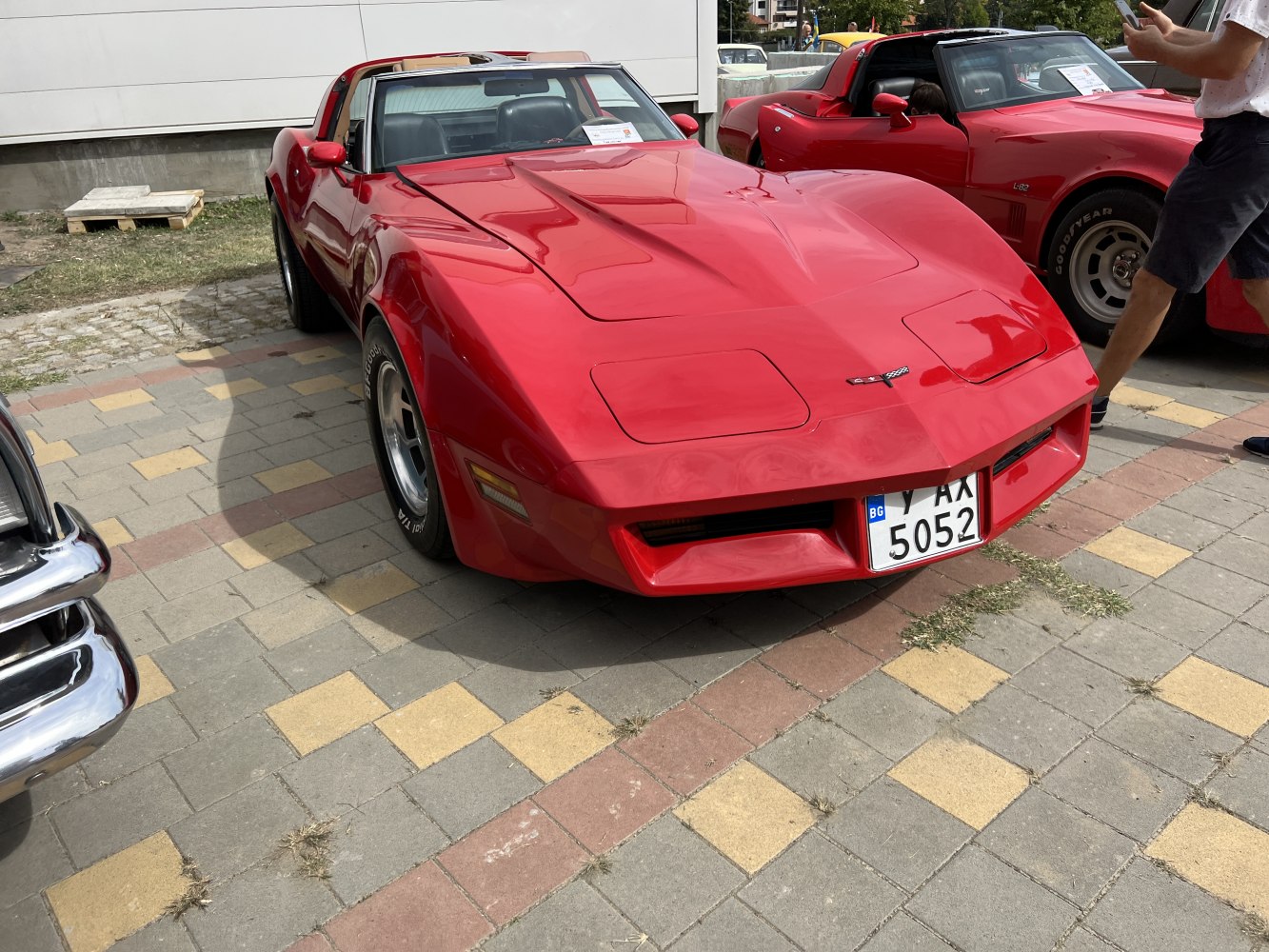 Red coupe with pop-up headlights and sleek aerodynamic front design.