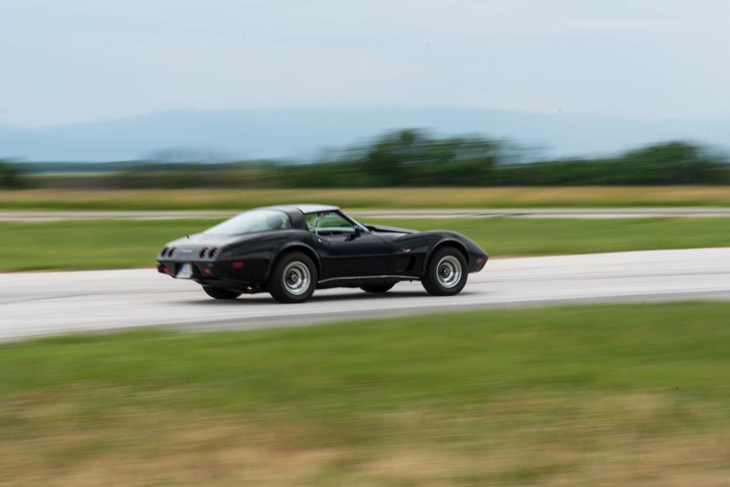 Black vintage sports coupe in motion with smooth curved design