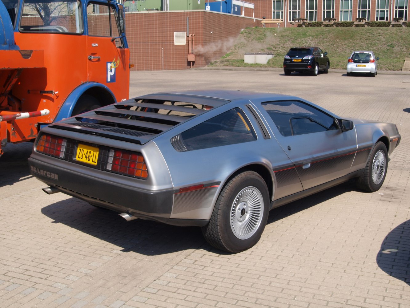 Stainless steel car rear view with rear louvers and unique wheel design.