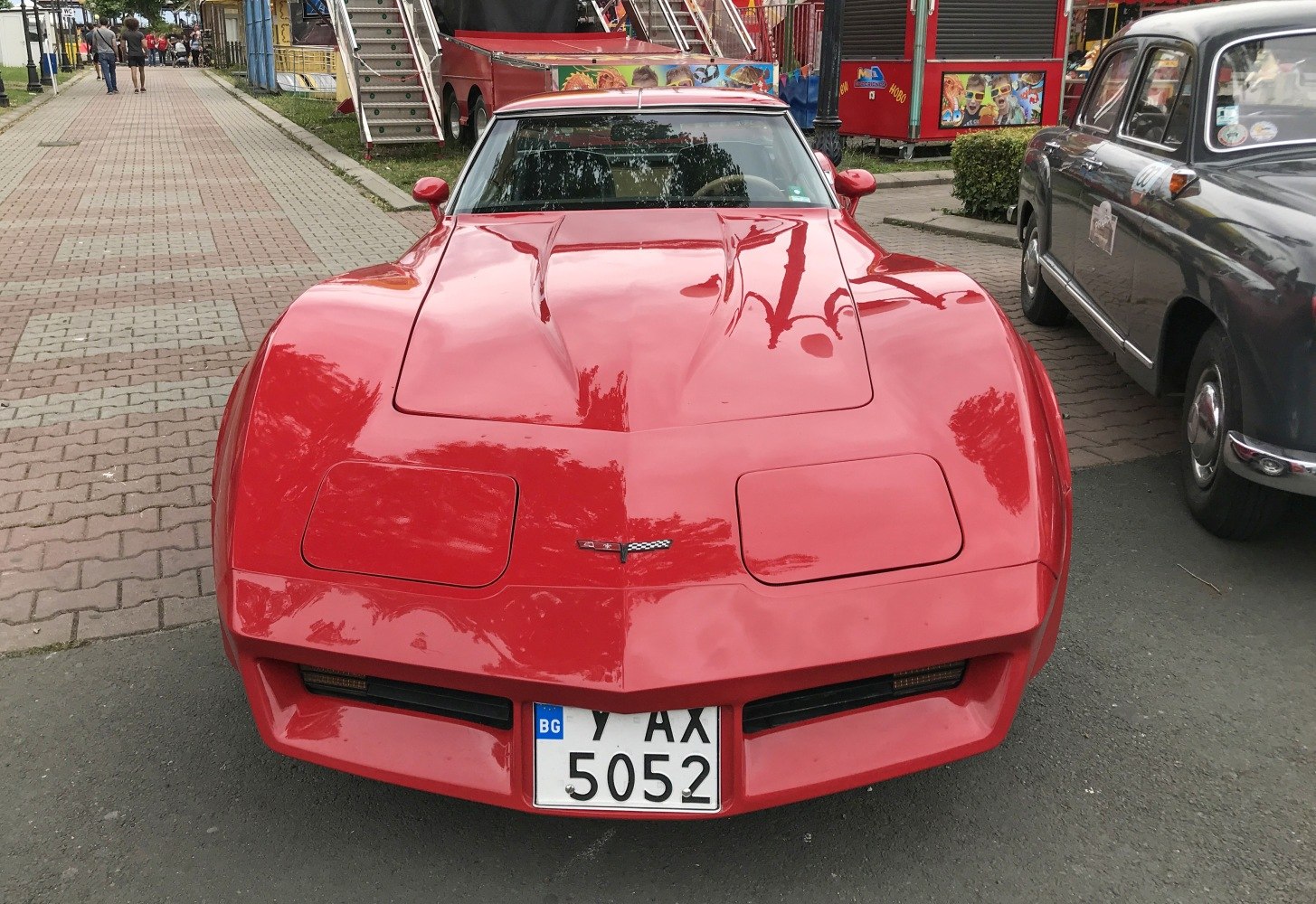 Front view of a red sports coupe with pop-up headlights and aerodynamic hood.