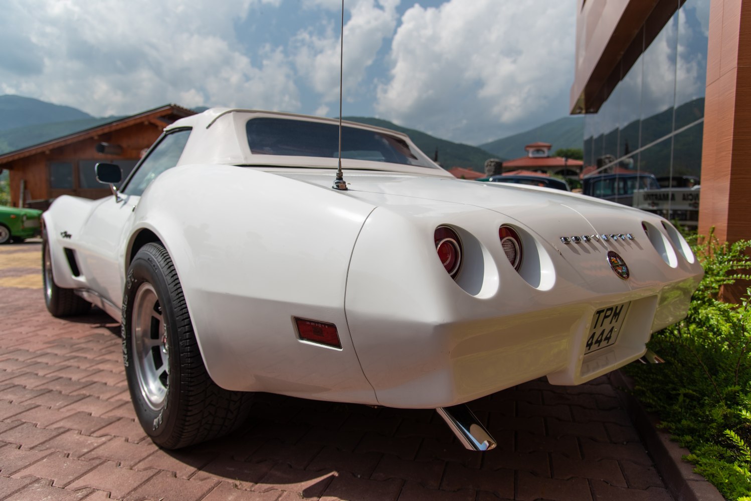 Rear angle with dual round taillights and white convertible top.