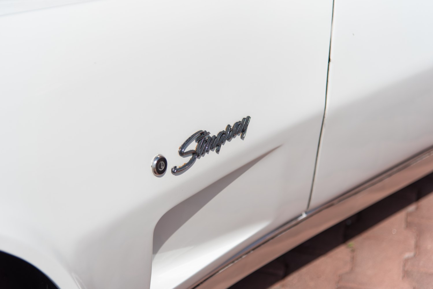 Close-up of Stingray side emblem on white vehicle body