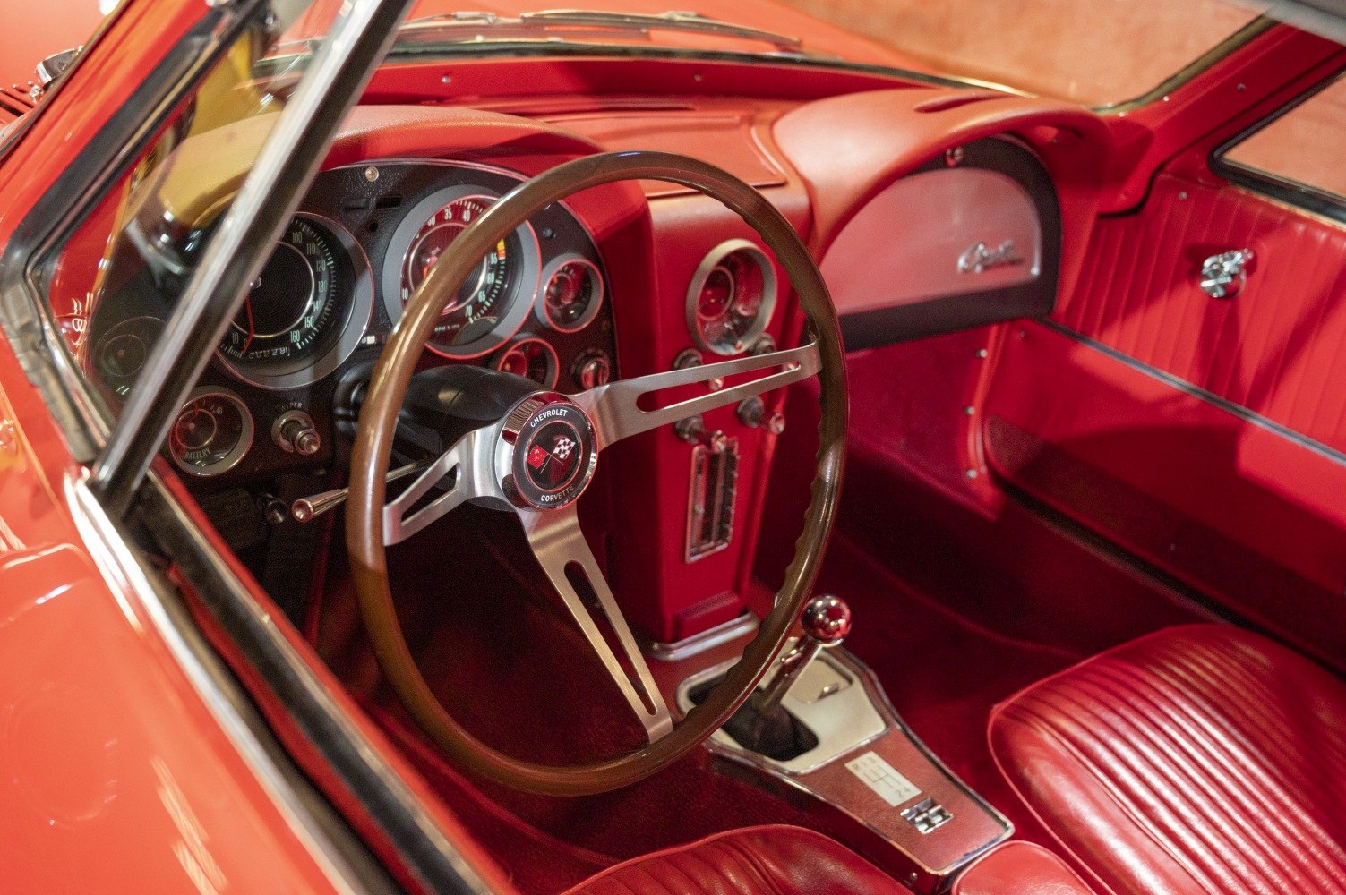Classic red interior with dashboard and wood steering wheel