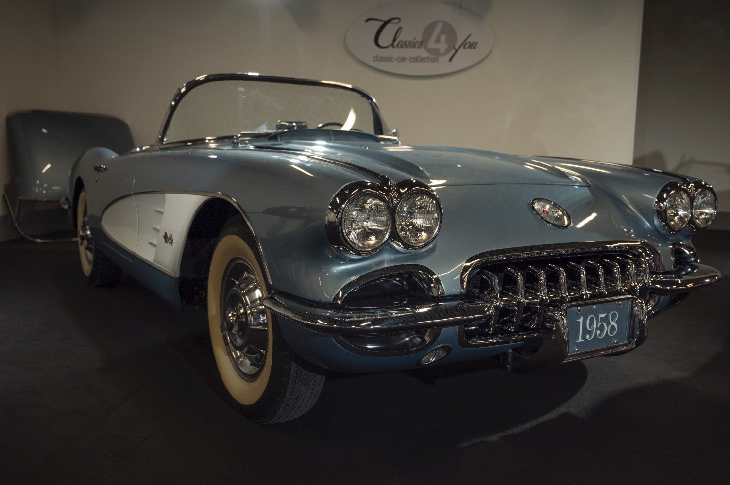 Convertible front-side view with dual round headlights and chrome grille
