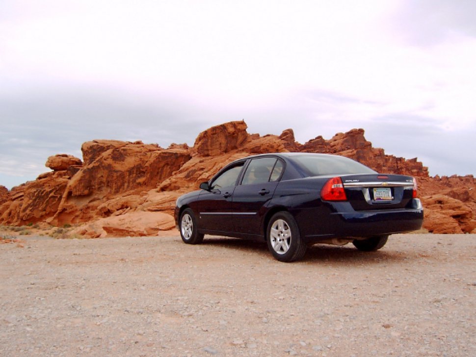 Rear side view of sedan with distinct tail lights and desert background