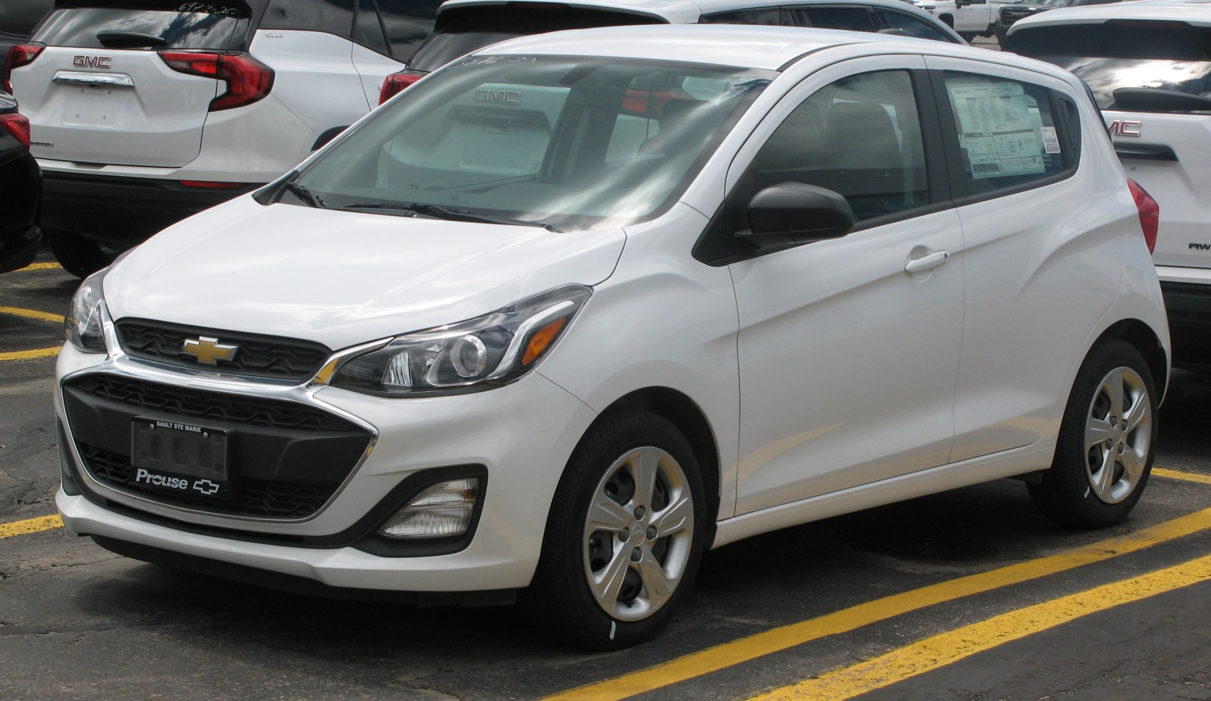 Front and side view of white compact hatchback with distinctive grille and headlights
