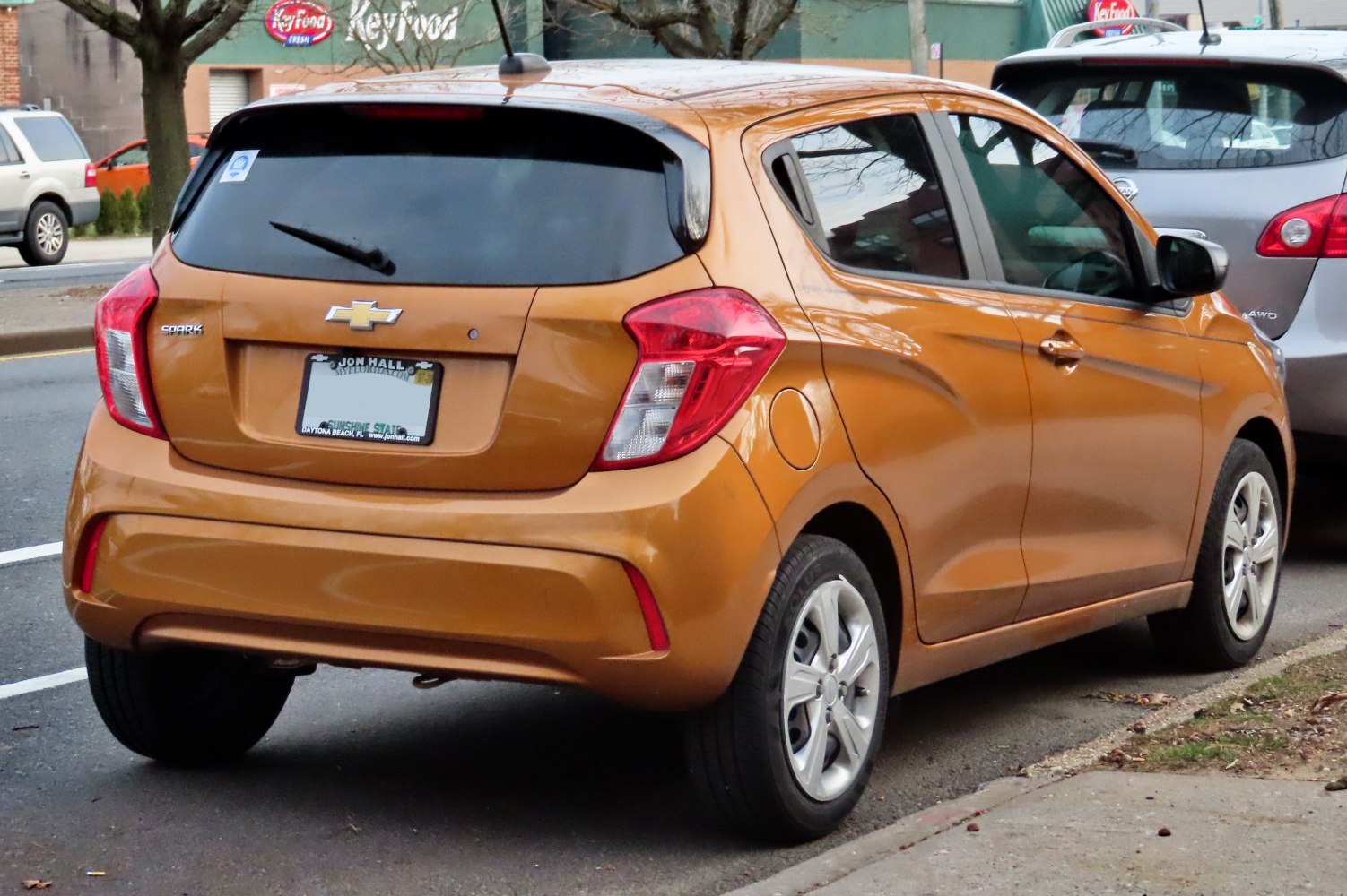 Rear view of compact hatchback with distinctive tail lights and orange color