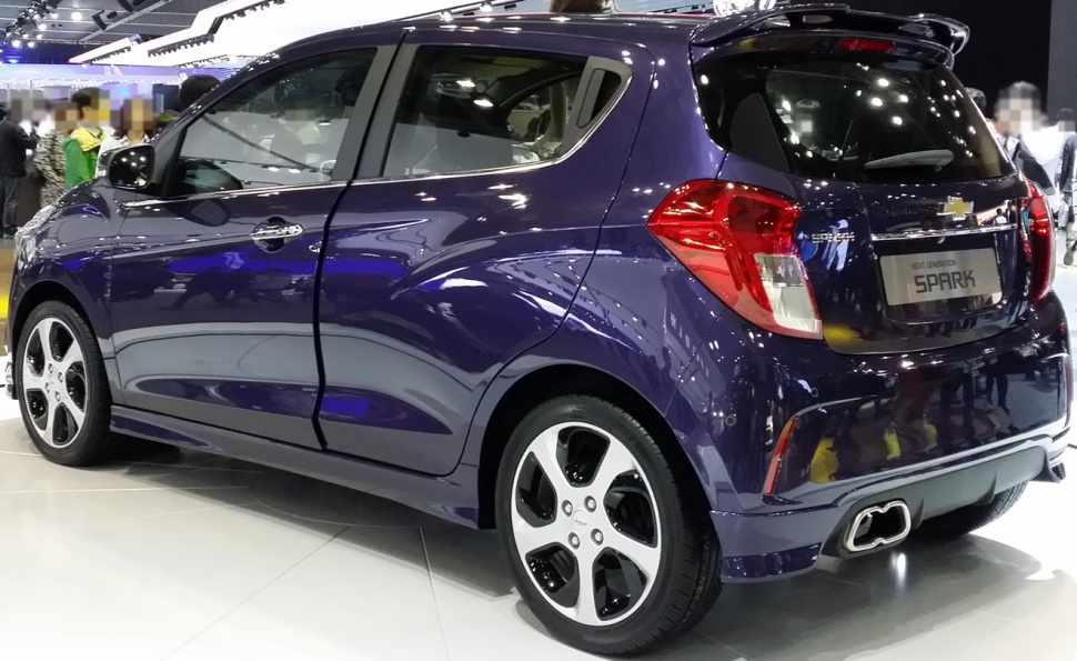 Rear and side view of a compact hatchback with distinctive tail lights and dual exhaust.