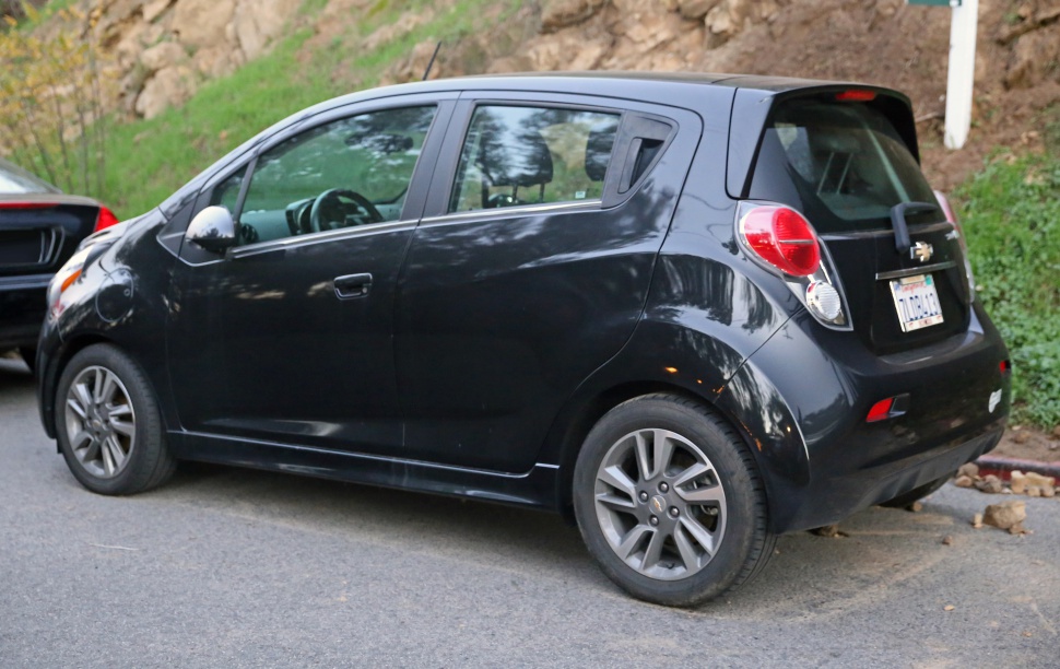 Compact hatchback rear-side with round tail lights and alloy wheels