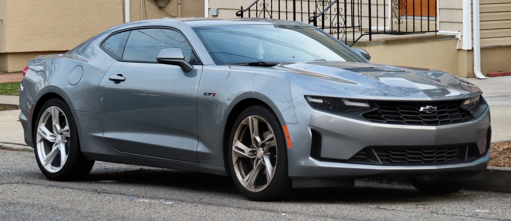Gray performance coupe front side view with aggressive grille and alloy wheels