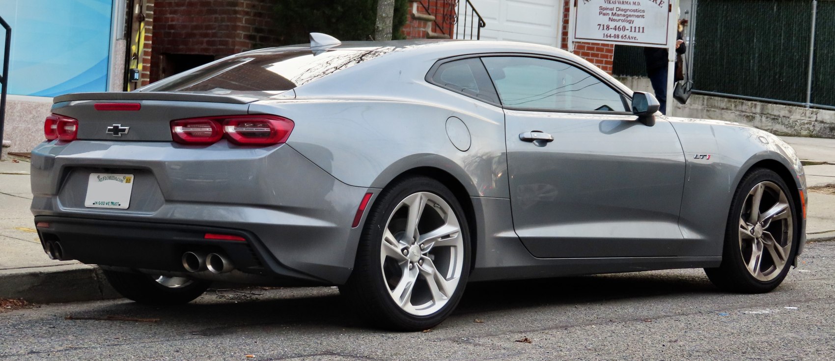 Rear and side profile of a coupe with dual exhaust and alloy wheels