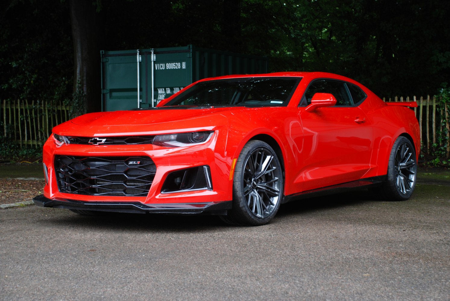 Aggressive front grille and sporty alloy wheels on a red muscle coupe