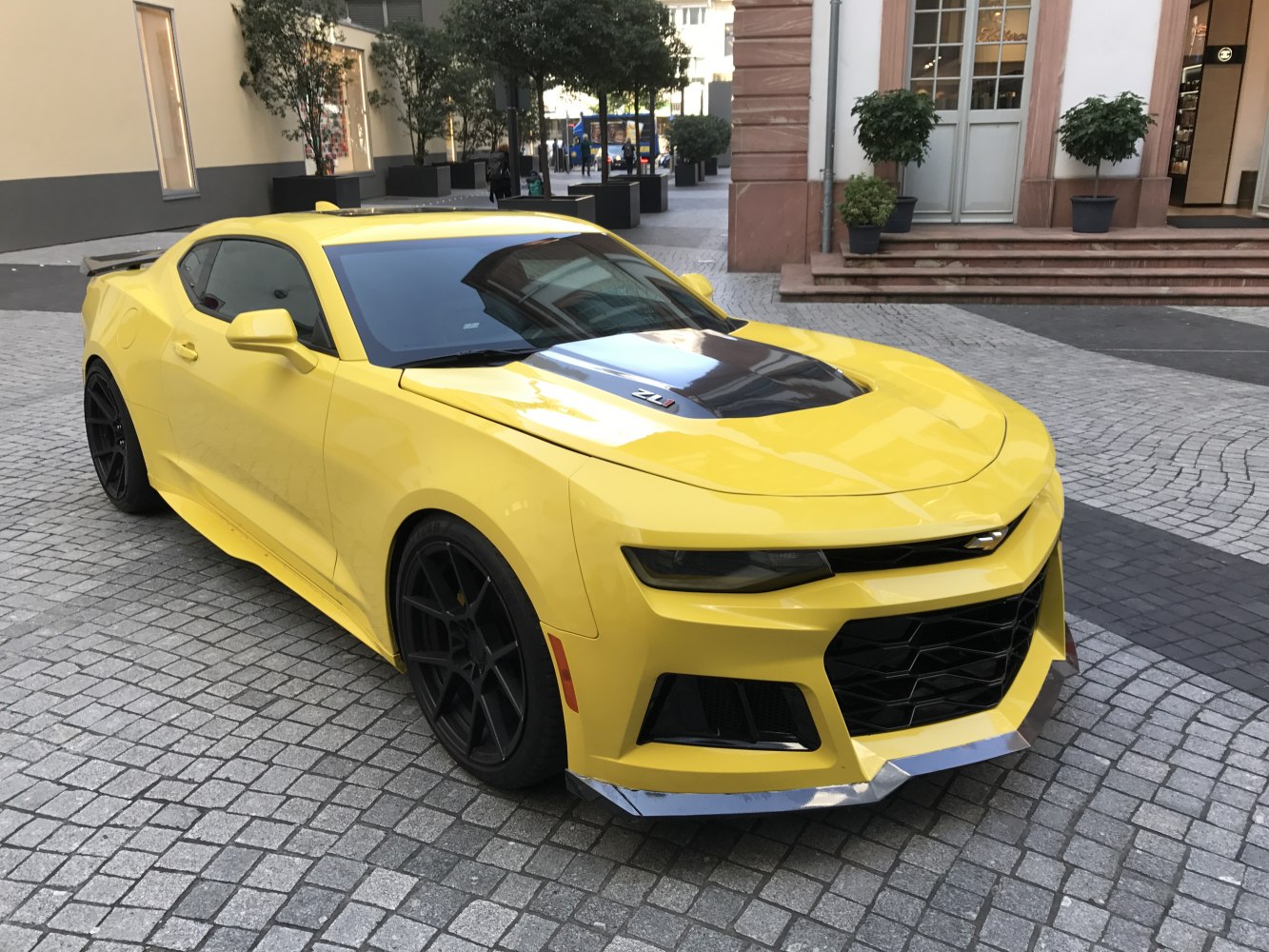 Yellow sports coupe with black hood and aggressive front grille