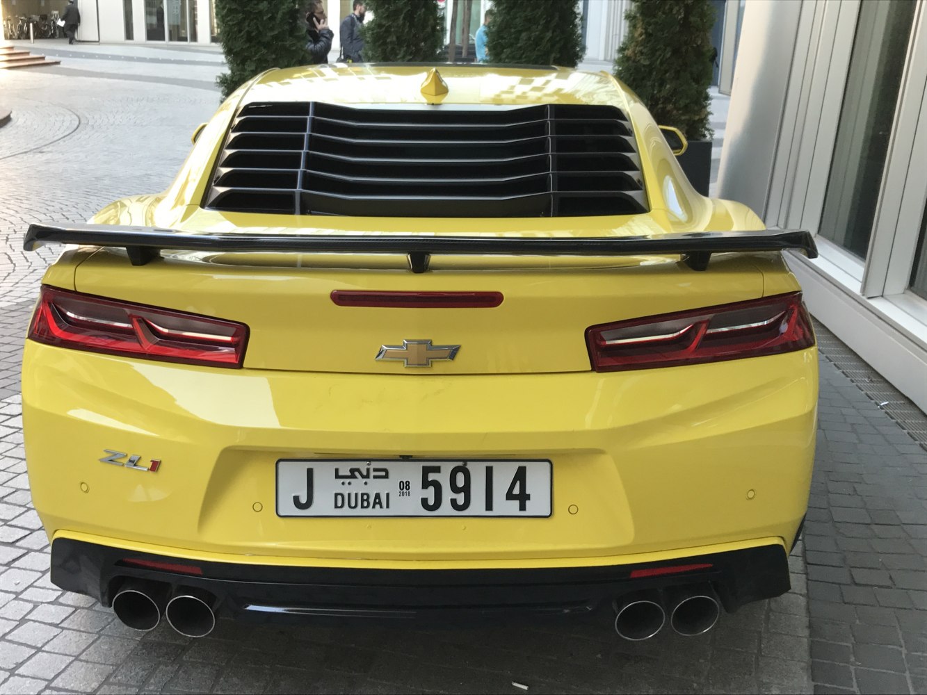 Rear view with spoiler, quad exhausts, and louvered rear window