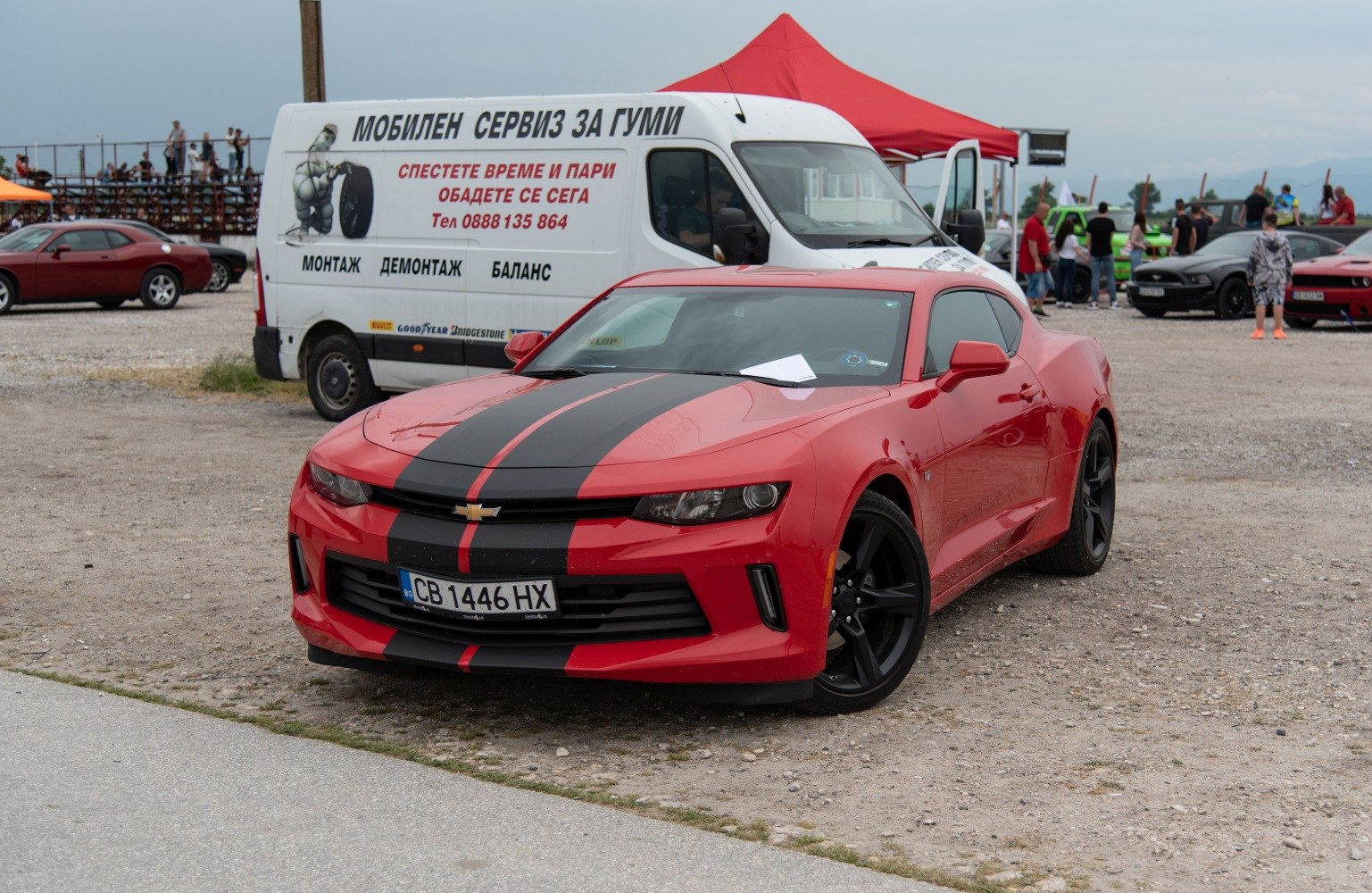 Red sports coupe with black racing stripe and black alloy wheels