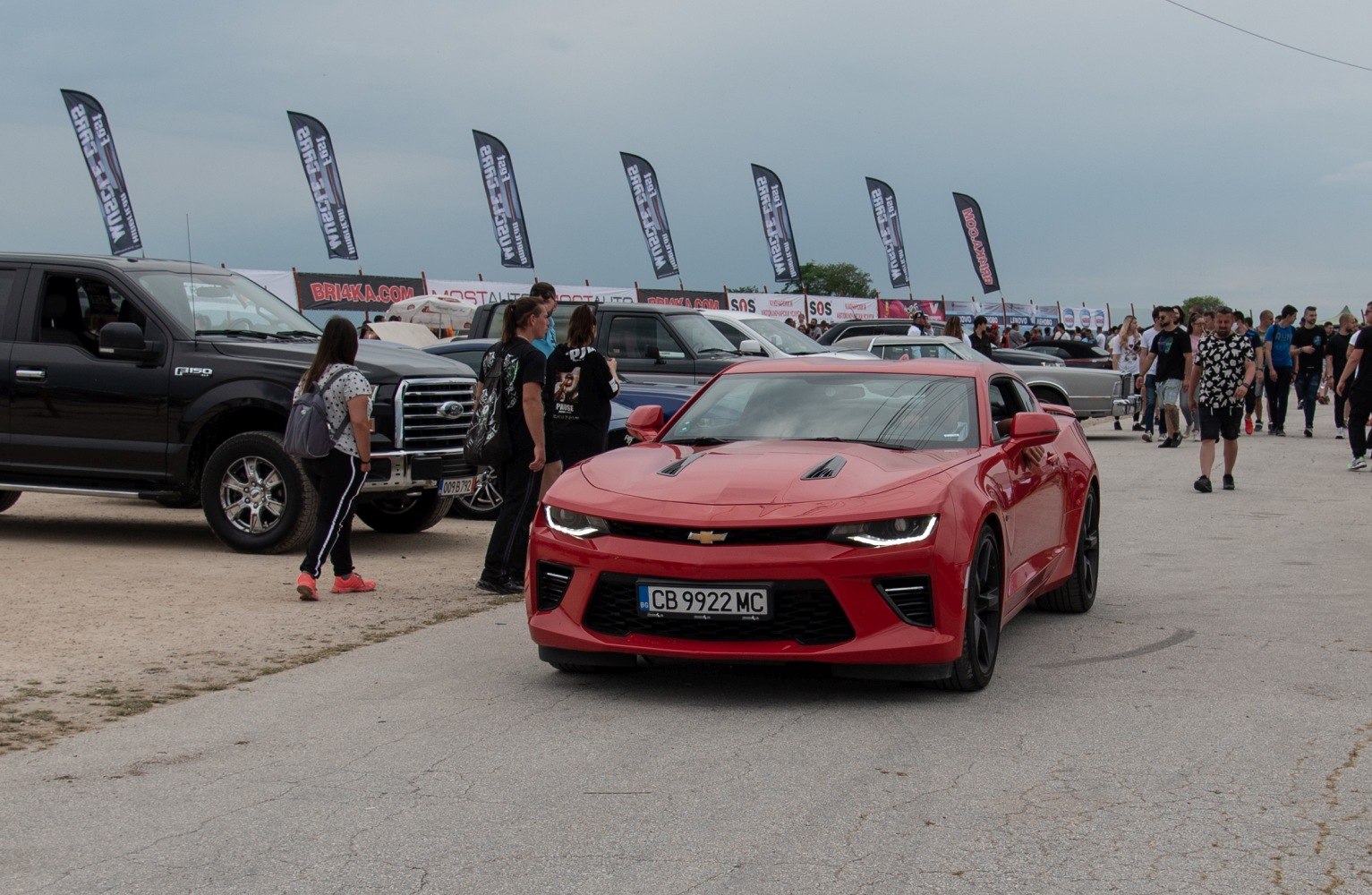 Red sport coupe front view with LED headlights and hood vents