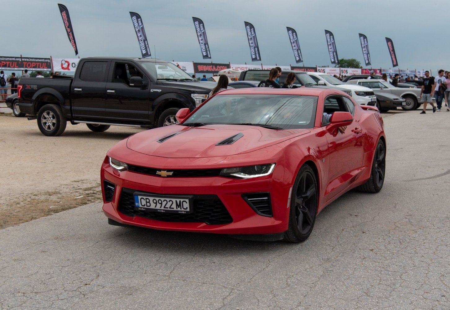 Red muscle coupe with aggressive front, hood vents