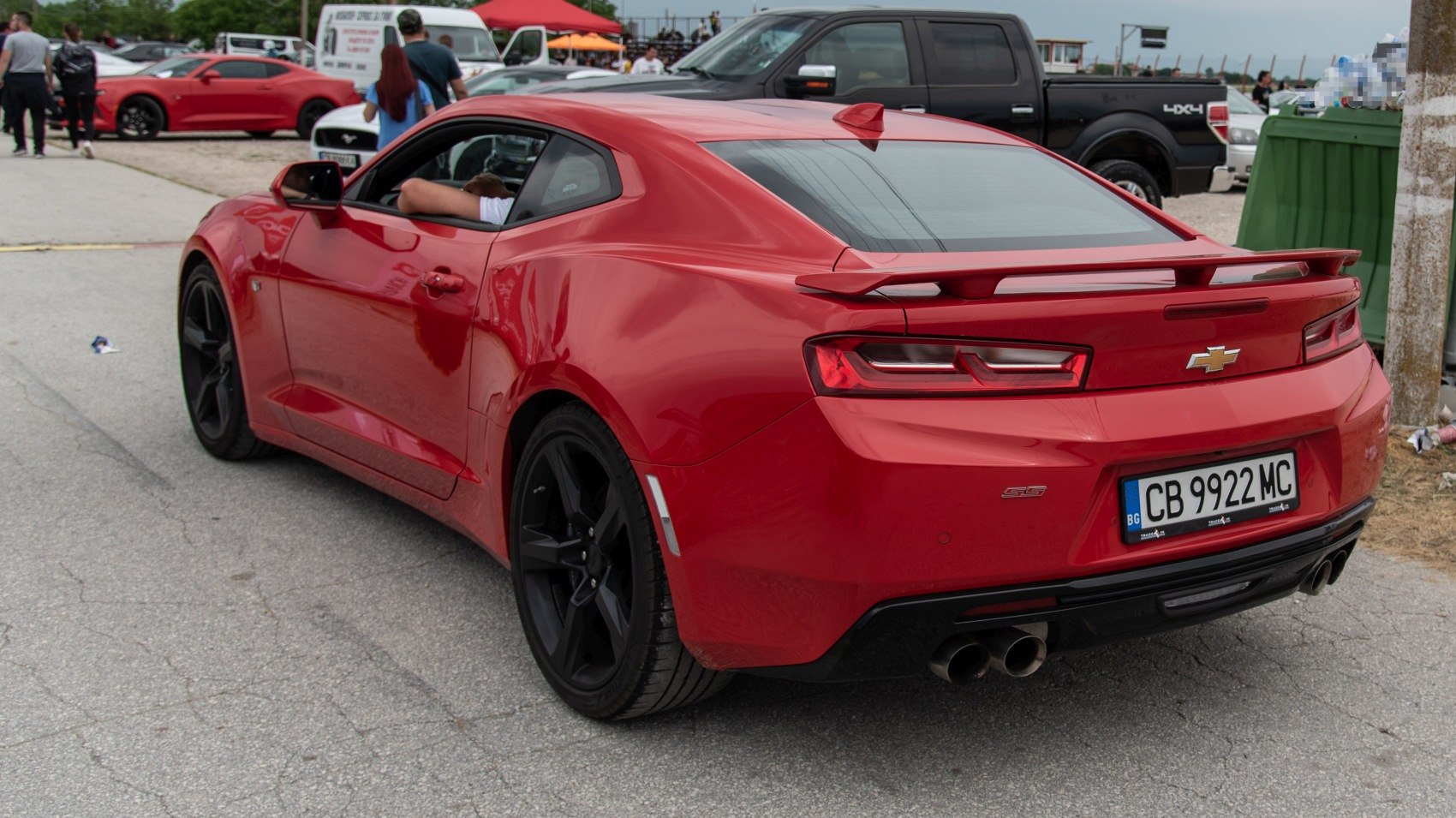 Rear-side red sports coupe with rear spoiler and dual exhaust