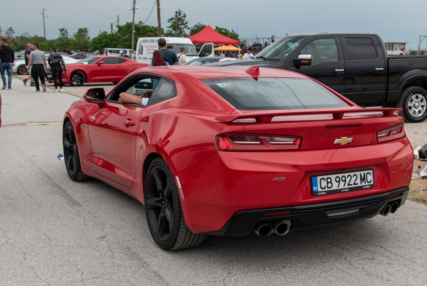 Red muscle coupe rear view with wing spoiler and black rims