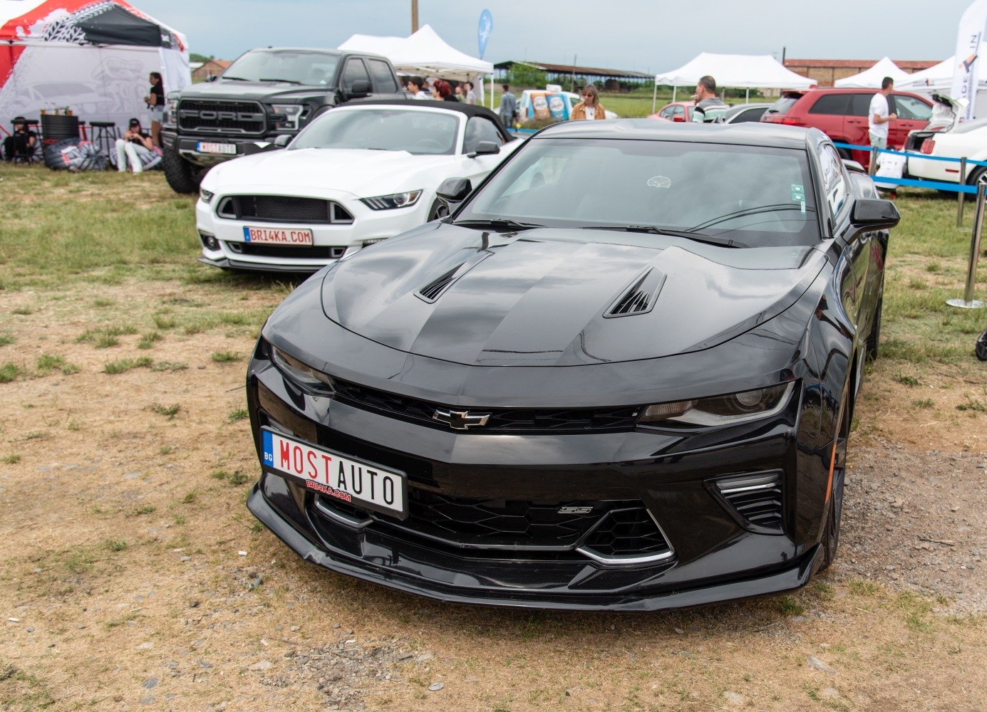 Black sports car front with aggressive hood vents and sharp headlights