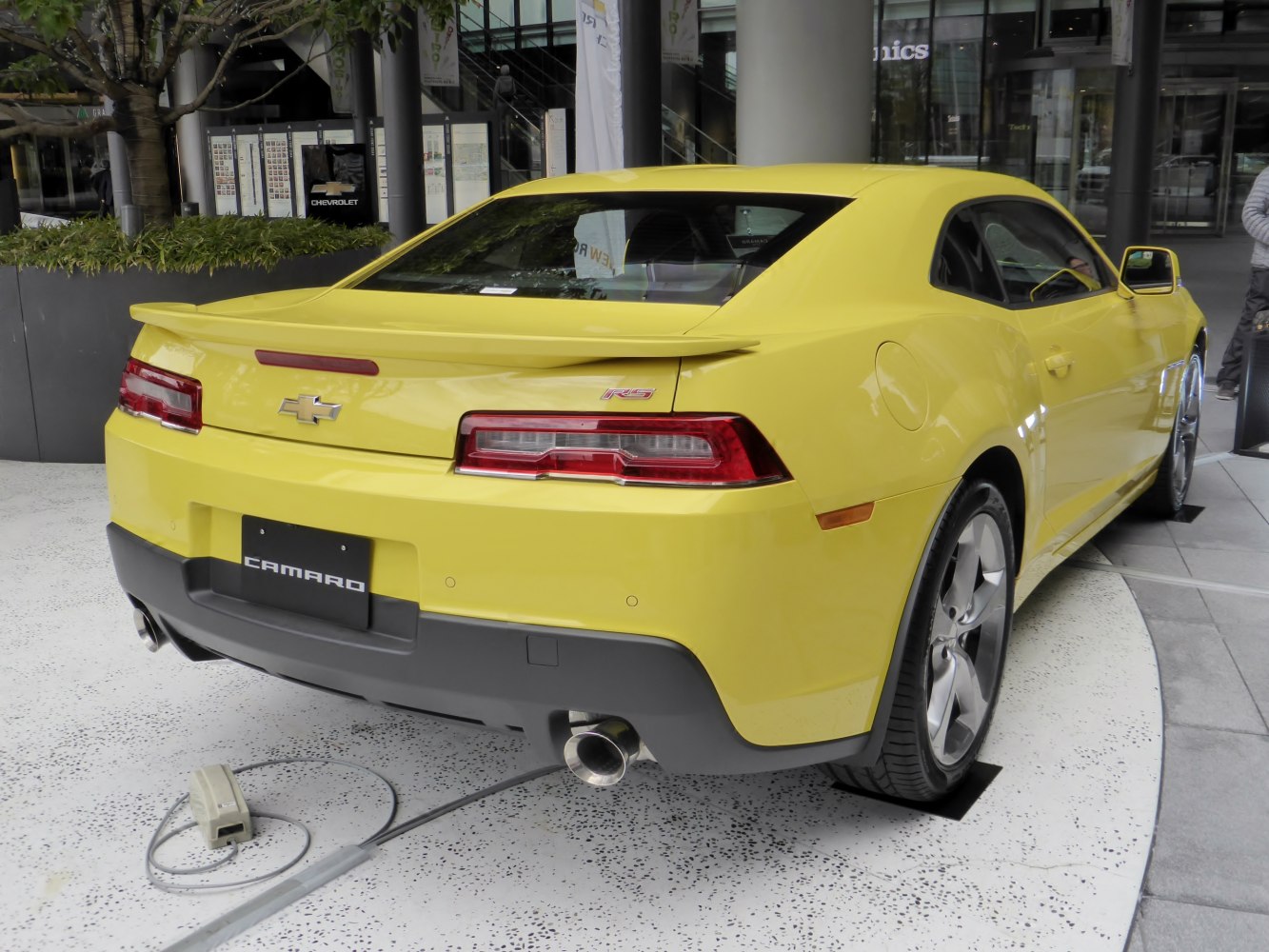 Yellow muscle car with RS badge and dual exhaust rear view