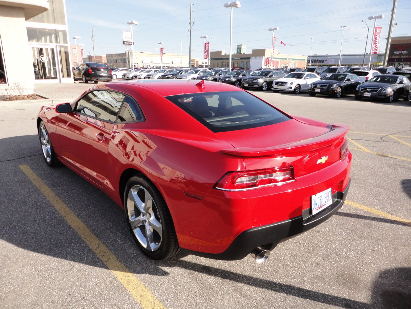 Red two-door sports coupe rear side, distinct taillights, and alloy wheels