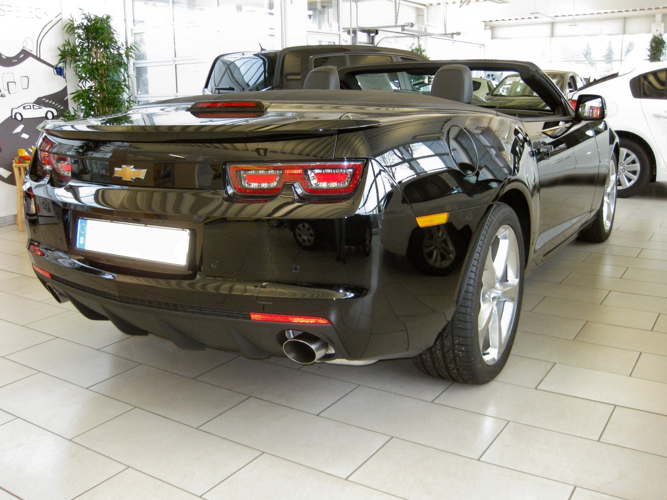 Rear view with distinct tail lights, rear bumper, and single exhaust pipe