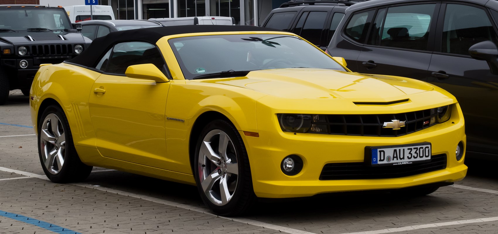 Yellow convertible with black soft top and five-spoke rims
