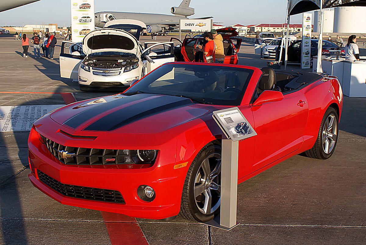 Red convertible with black racing stripes and alloy wheels