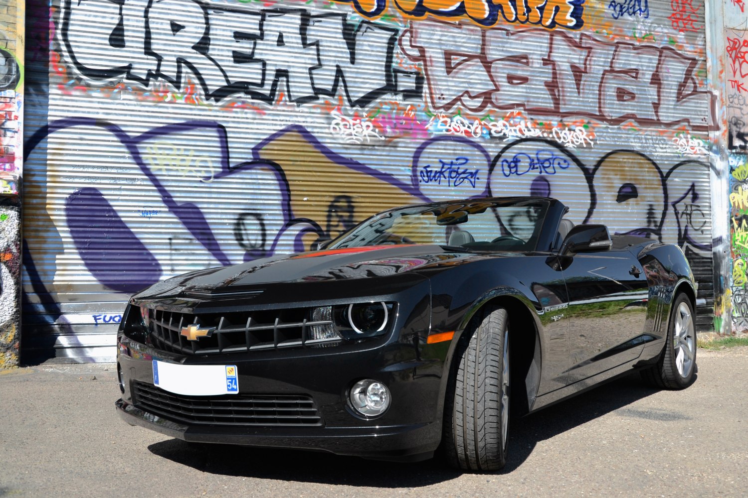 Front view of a black convertible with sporty grille and headlights