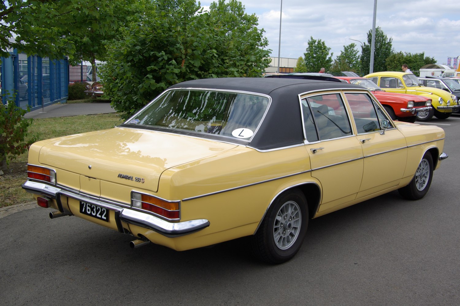 Yellow classic sedan with black vinyl roof and dual rear exhausts