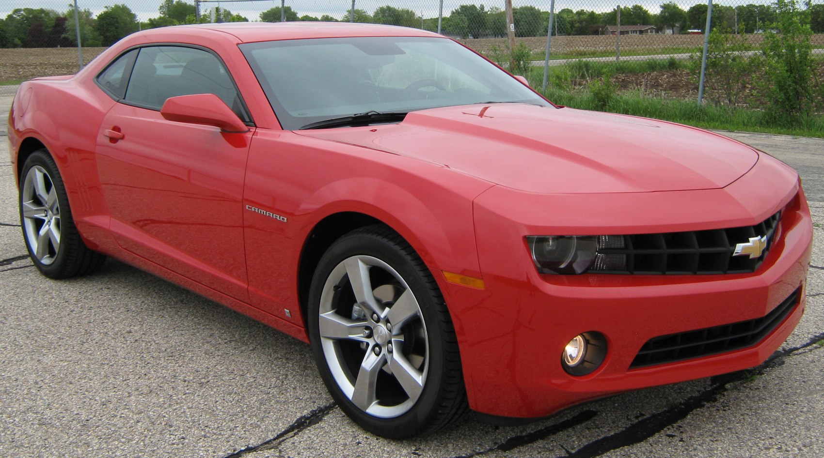 Red sporty coupe with aggressive front-side design and distinct alloy wheels