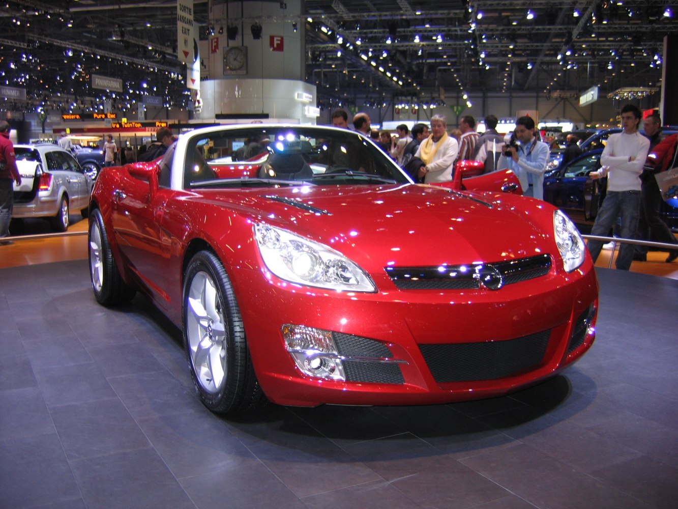 Red convertible sports car with sleek headlights and front grille