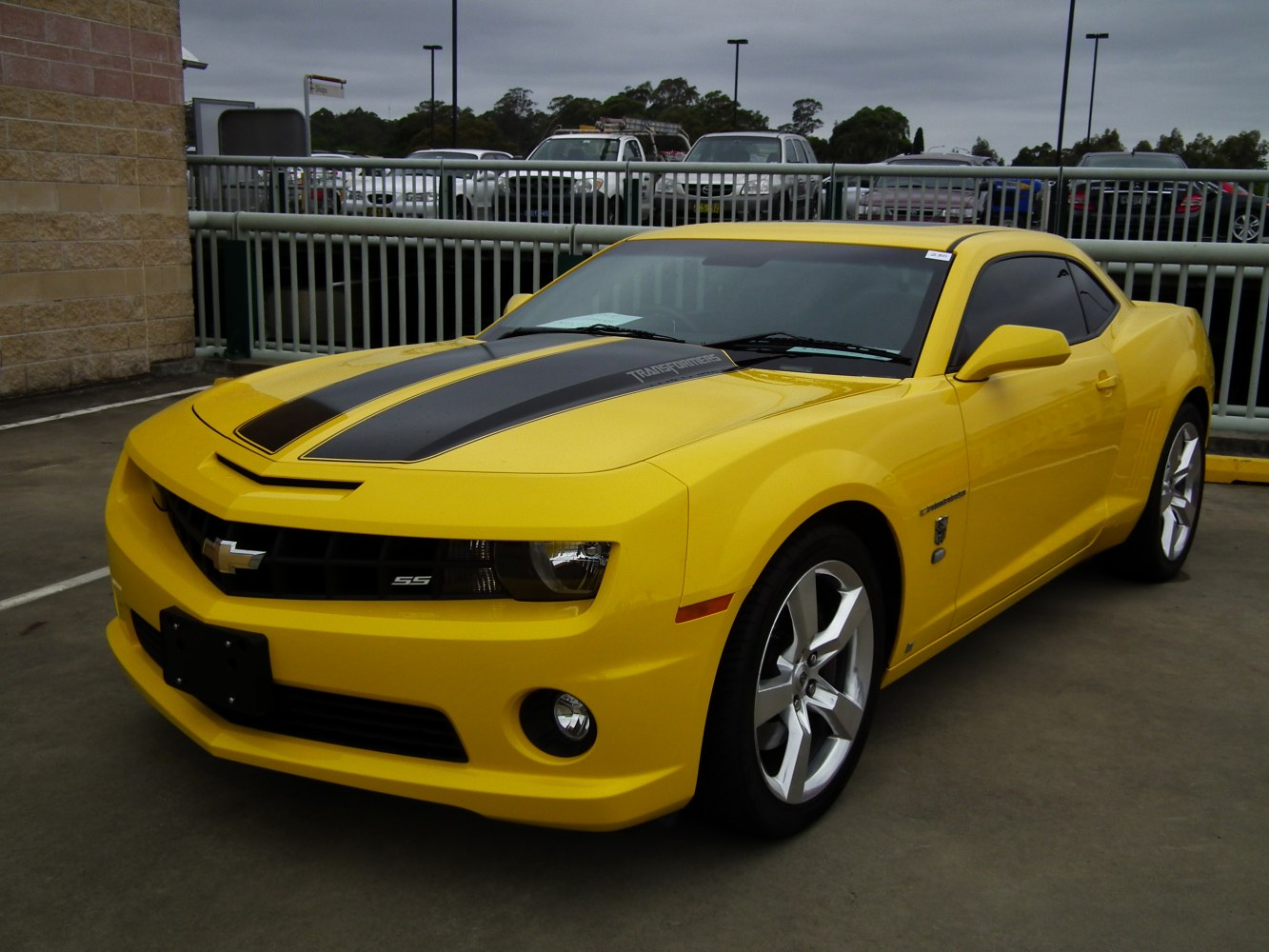 Yellow muscle coupe with black racing stripes and SS badge