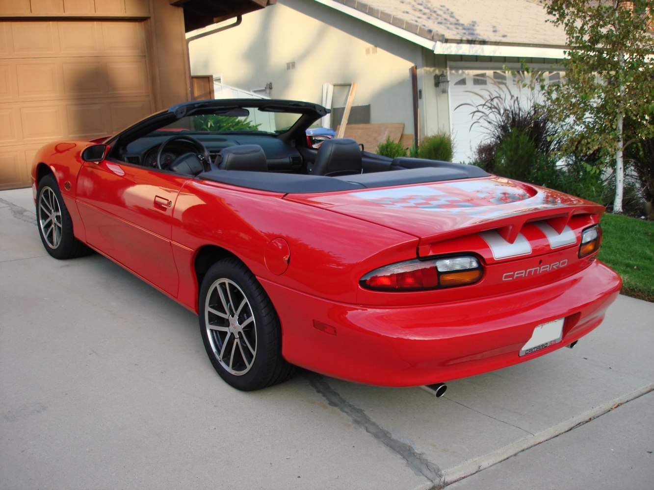 Red convertible with sleek rear side design and sporty rims.