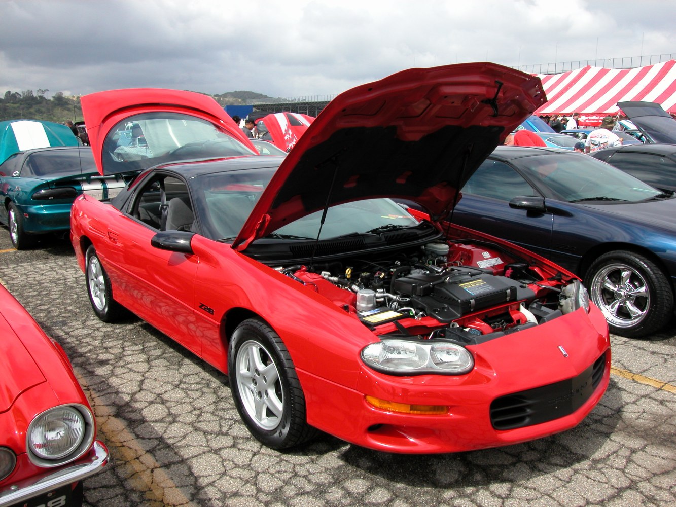 Red muscle coupe with open hood showing engine bay