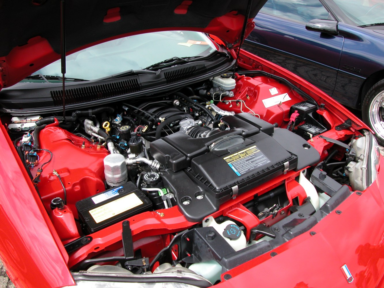 Detailed engine bay with V8 and components in a red vehicle