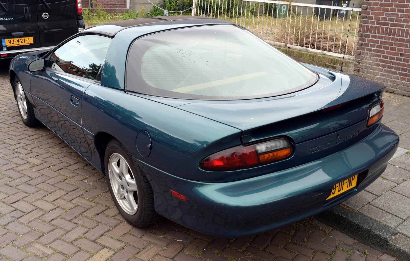 Rear and side view of a 1990s sports coupe with T-top roof and rear spoiler