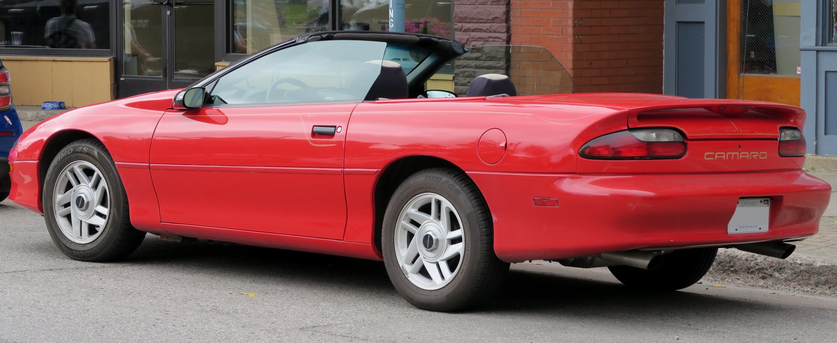 Rear side view of a red convertible with sporty design and distinct taillights