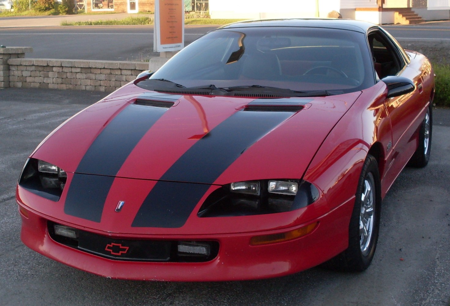 Front view showing black dual racing stripes and angled headlights