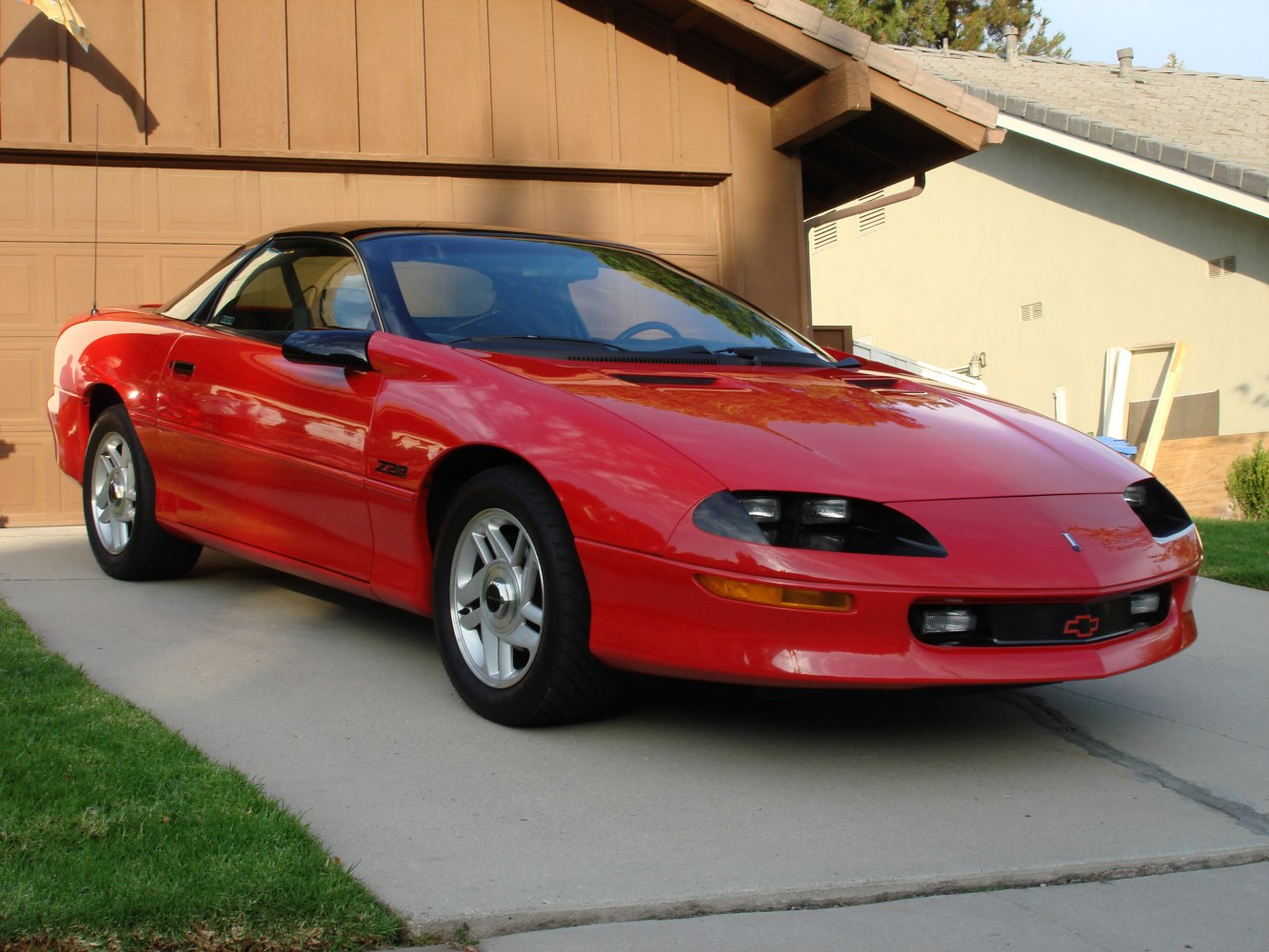 Red 1993 muscle car with aerodynamic front and pop-up headlights